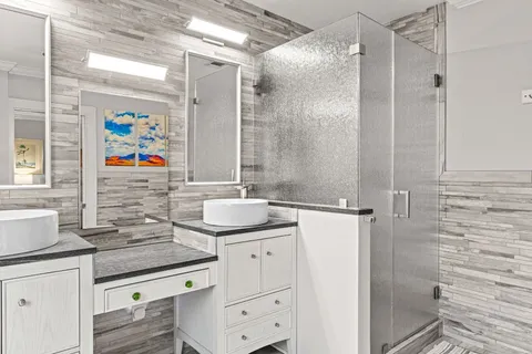a bathroom with a granite countertop sink a shower and a mirror