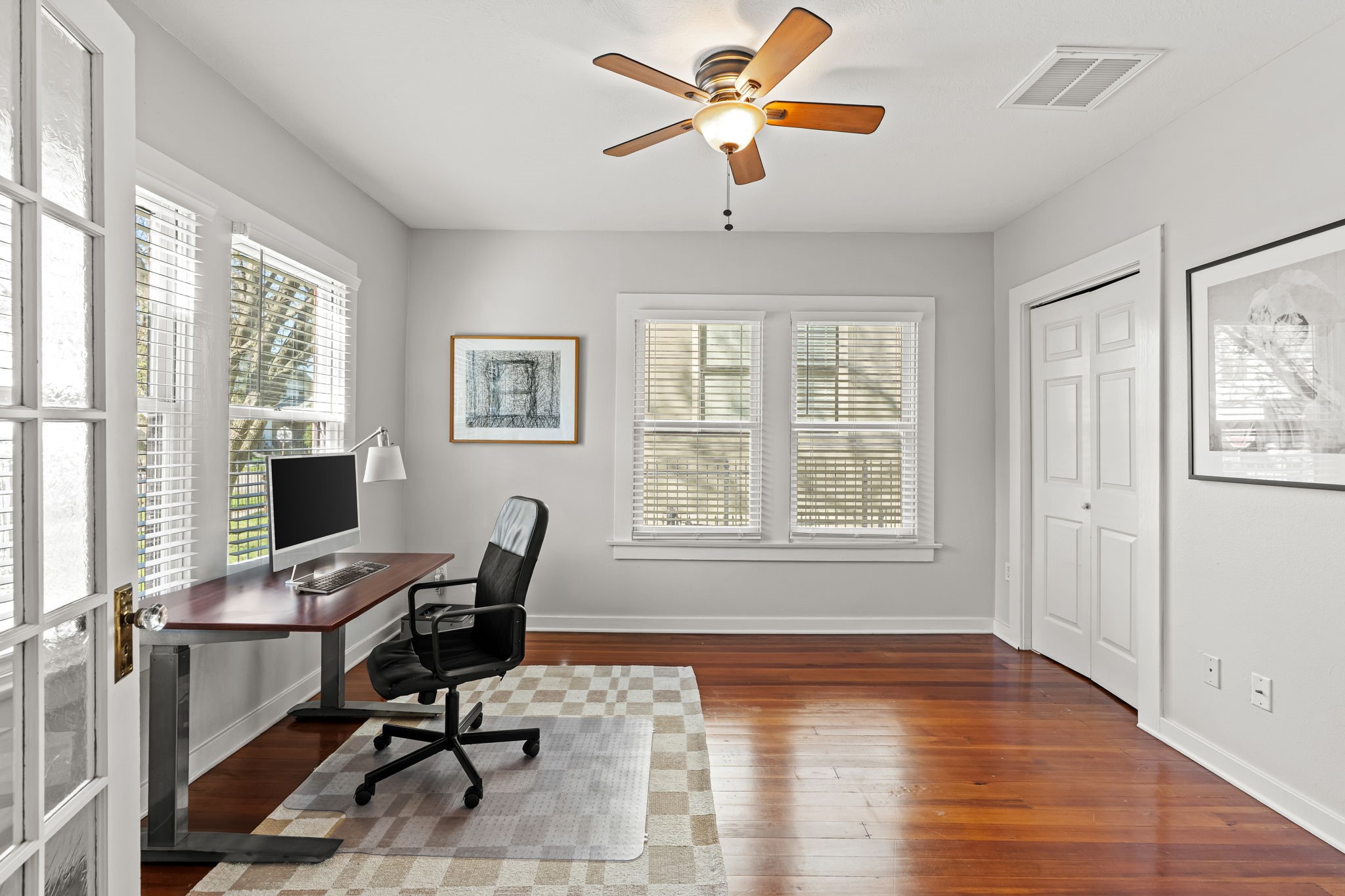805 Ralfallen Street Houston, TX 77008 - Photo 16 of 32 Bright front bedroom featuring hardwood floors, multiple windows for natural light, and a convenient closet for storage.