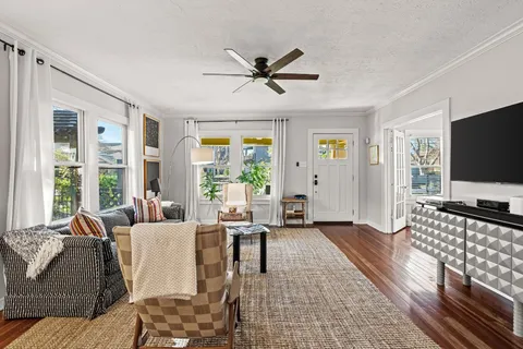 a living room with furniture a flat screen tv and a large window