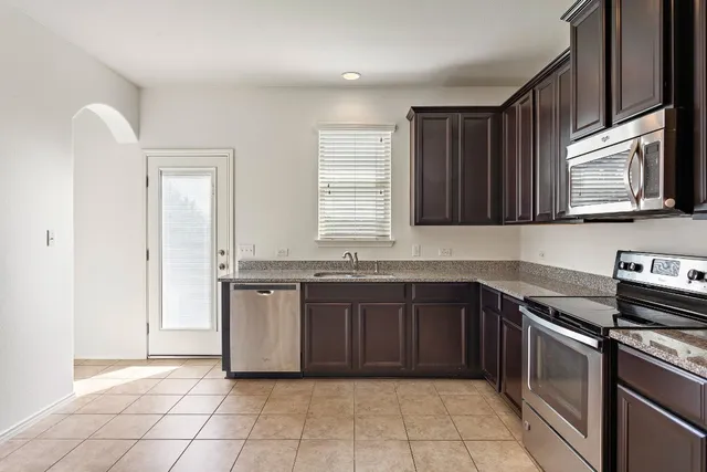 a kitchen with stainless steel appliances granite countertop a stove and a sink