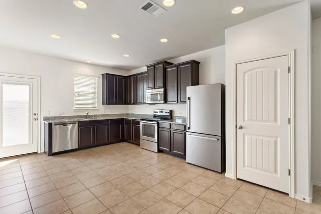 a kitchen with stainless steel appliances granite countertop wooden cabinets a stove top oven a sink and dishwasher