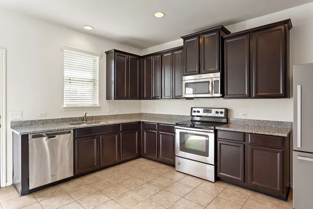 a kitchen with stainless steel appliances granite countertop a sink and a stove