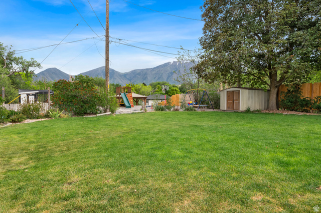 523 South Main Street Payson, UT 84651 - Photo 39 of 41 Spacious backyard featuring a large grassy area, mature tree, and a storage shed with double doors