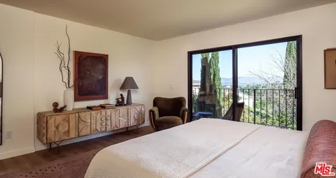 a bedroom with bed and large window