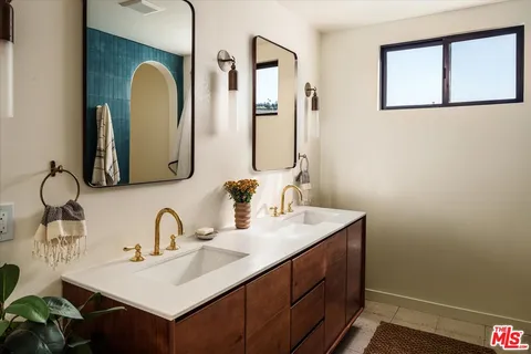a bathroom with a double vanity sink and a mirror