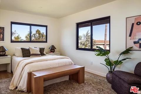 a bedroom with a bed and a painting on the wall