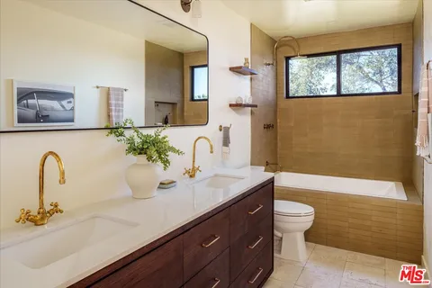 a bathroom with a granite countertop sink and a bathtub