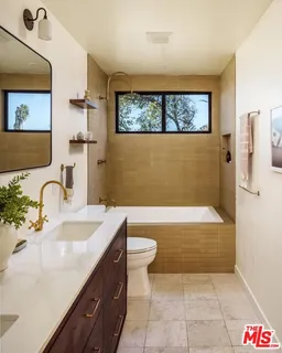 a bathroom with a tub a sink and a large mirror