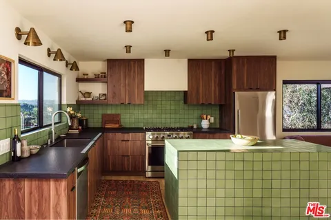 a kitchen with granite countertop a sink a stove and wooden cabinets