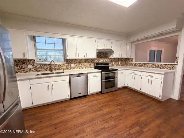 a kitchen with stainless steel appliances granite countertop a stove sink and cabinets