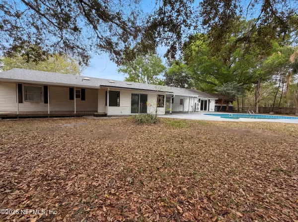 a front view of house with yard and trees around
