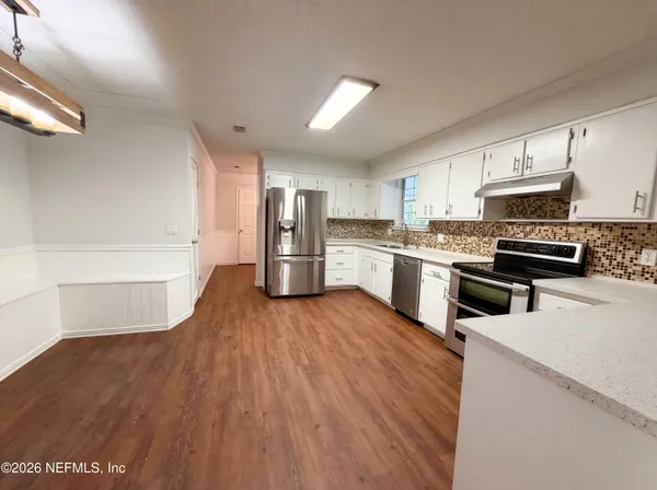 a kitchen with stainless steel appliances a refrigerator and a stove top oven