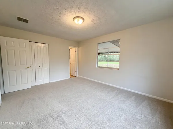 an empty room with windows and closet