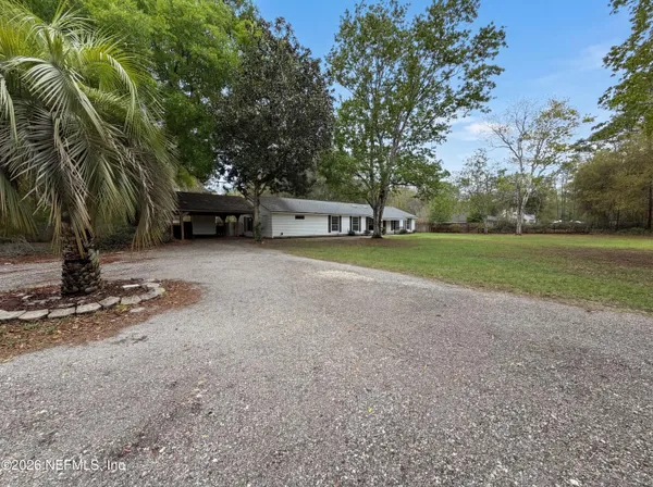 a view of a house with backyard and a tree