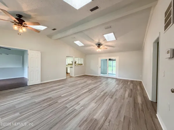 wooden floor in an empty room with a window