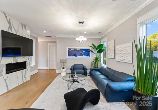 a dining room with furniture potted plants and wooden floor