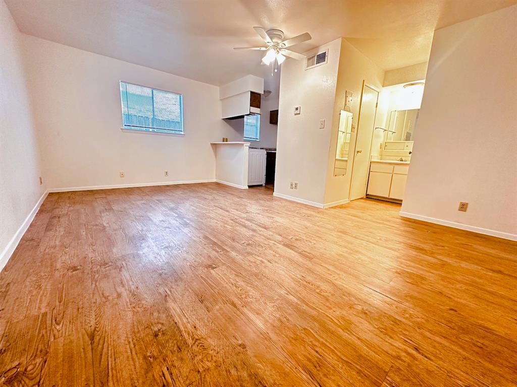 Unfurnished living room with light wood-style flooring and ceiling fan