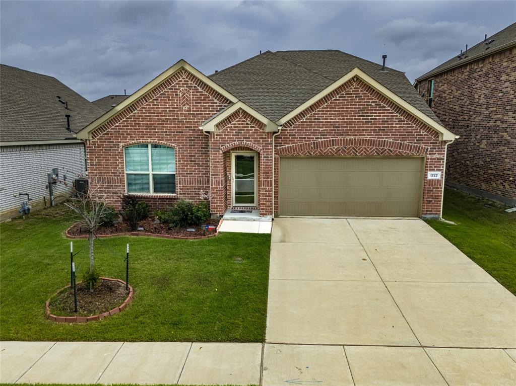 1222 Sequoia Lane Princeton, TX 75407 - Photo 25 of 29 View of front facade with brick siding, roof with shingles, an attached garage, and a front yard
