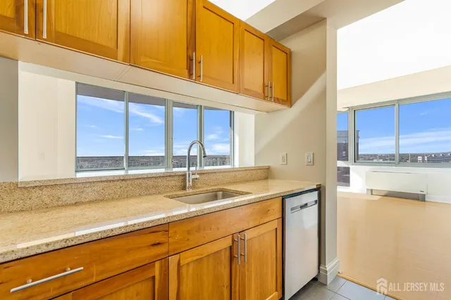 a kitchen with stainless steel appliances granite countertop a sink and a white cabinets