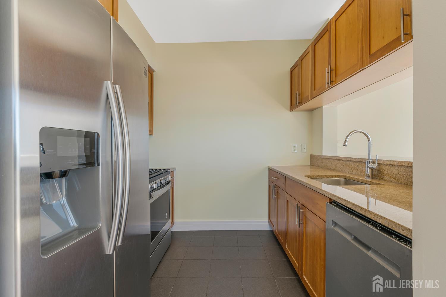 1 Spring Street, Unit 1704 New Brunswick, NJ 08901 - Photo 13 of 44 a kitchen with stainless steel appliances granite countertop a refrigerator and a sink