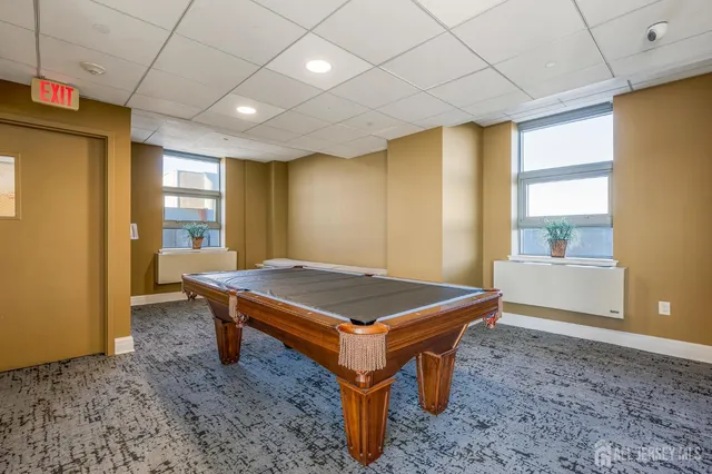 a room with pool table and windows