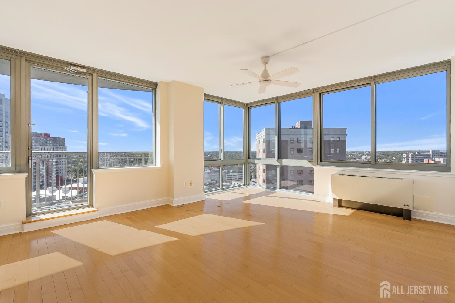 1 Spring Street, Unit 1704 New Brunswick, NJ 08901 - Photo 6 of 44 a large kitchen with kitchen island a large window a sink and cabinets