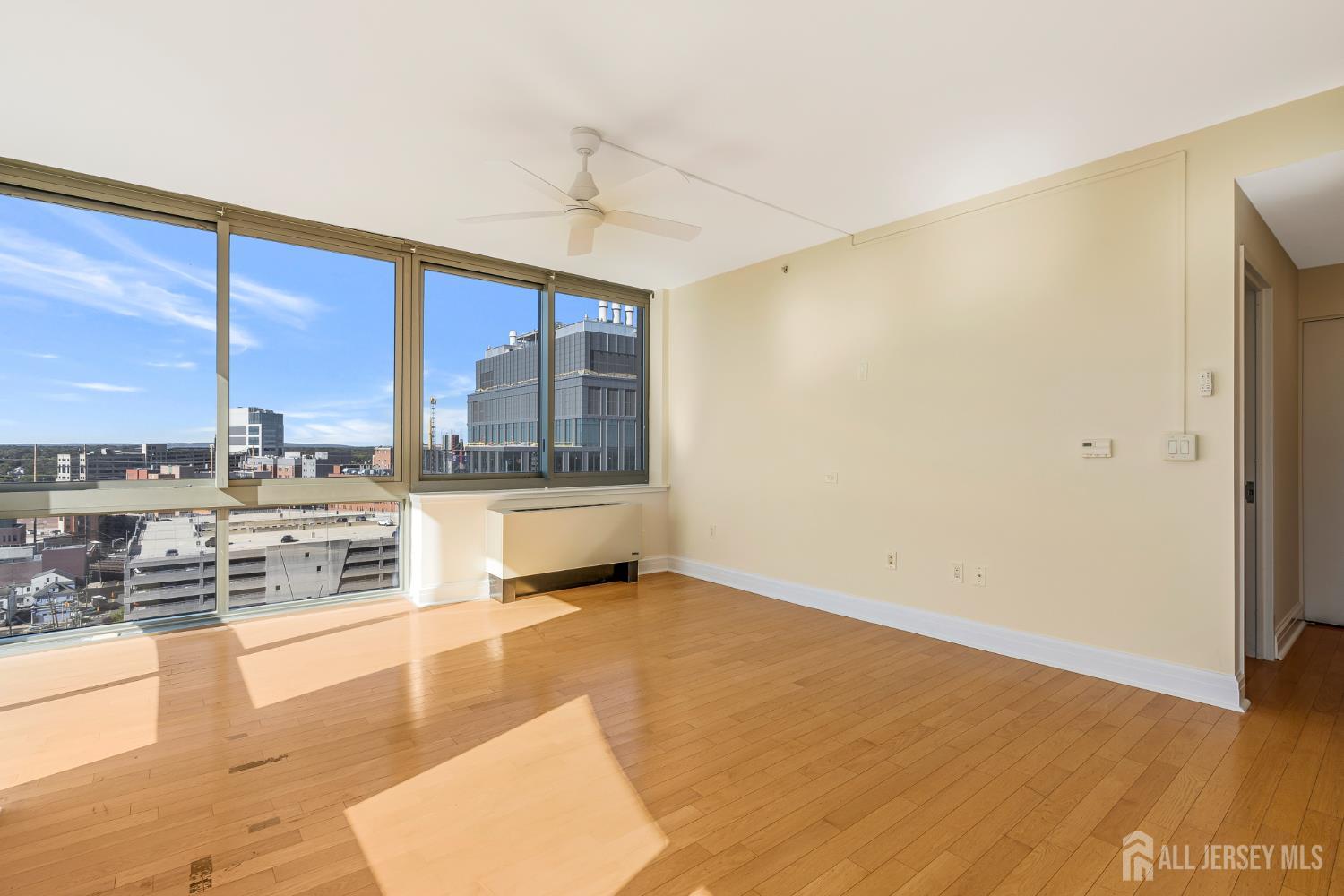 1 Spring Street, Unit 1704 New Brunswick, NJ 08901 - Photo 7 of 44 a view of a living room hardwood floor and a large window