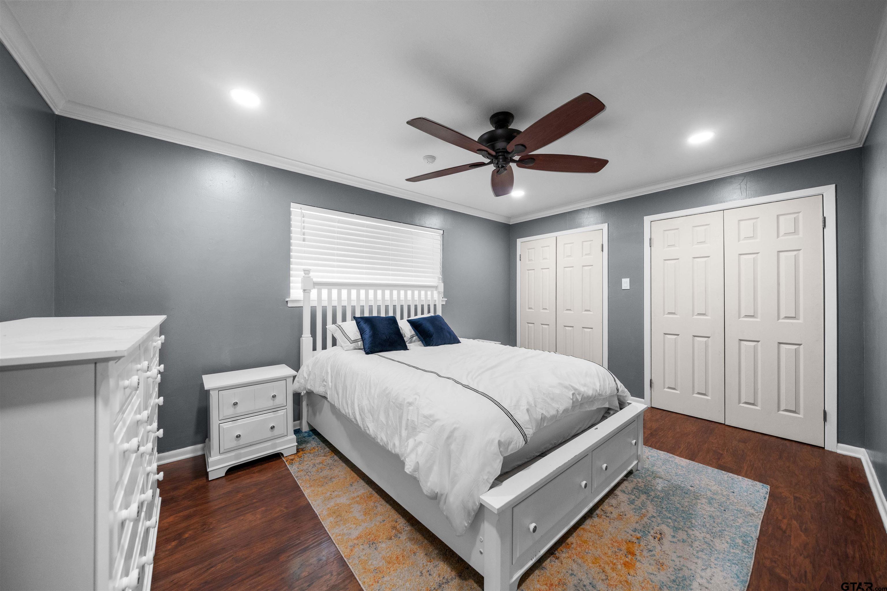 4107 Chester Drive Tyler, TX 75701 - Photo 2 of 45 a bedroom with a large bed chandelier and a window
