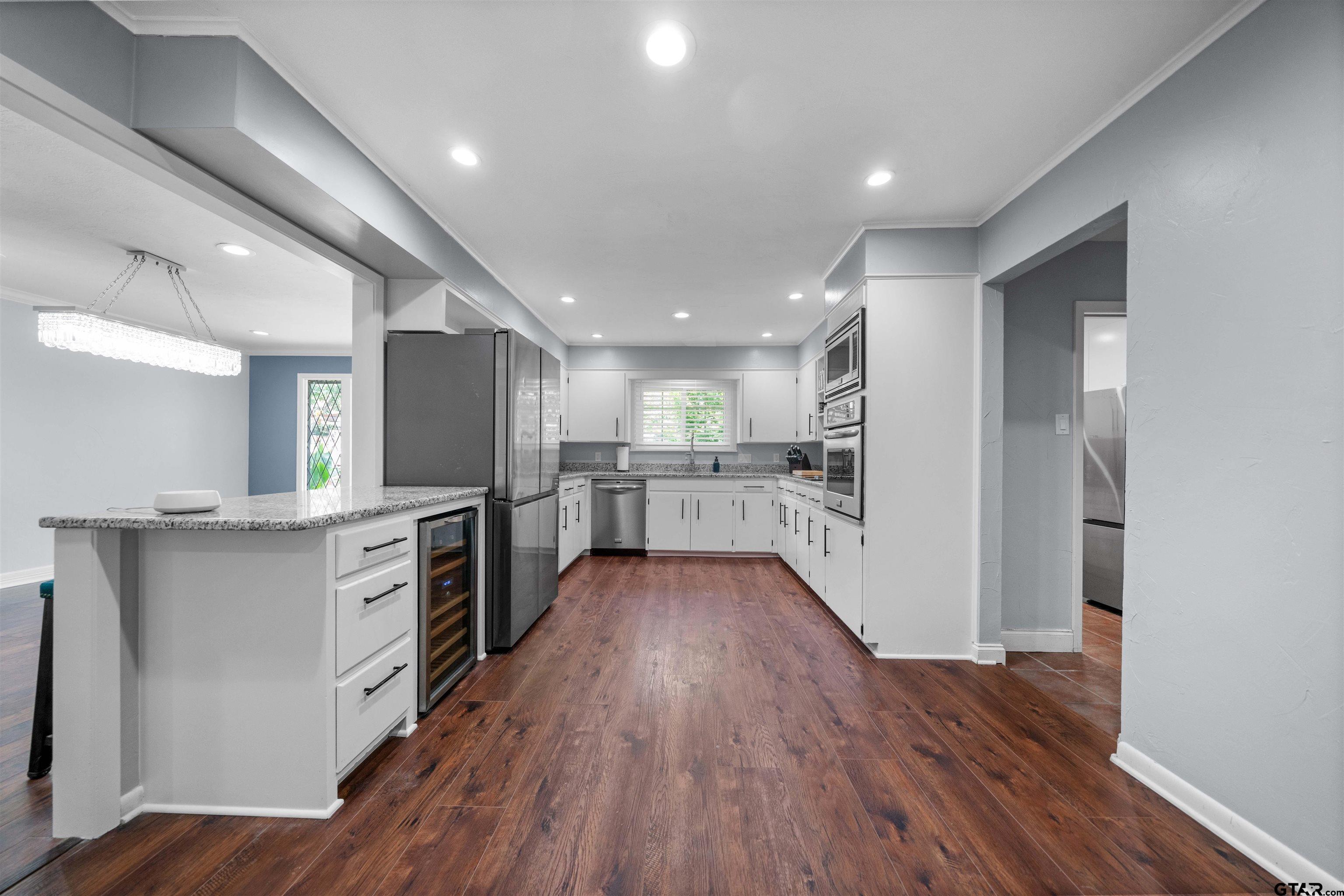 4107 Chester Drive Tyler, TX 75701 - Photo 10 of 45 a large kitchen with stainless steel appliances kitchen island a large counter top and a refrigerator