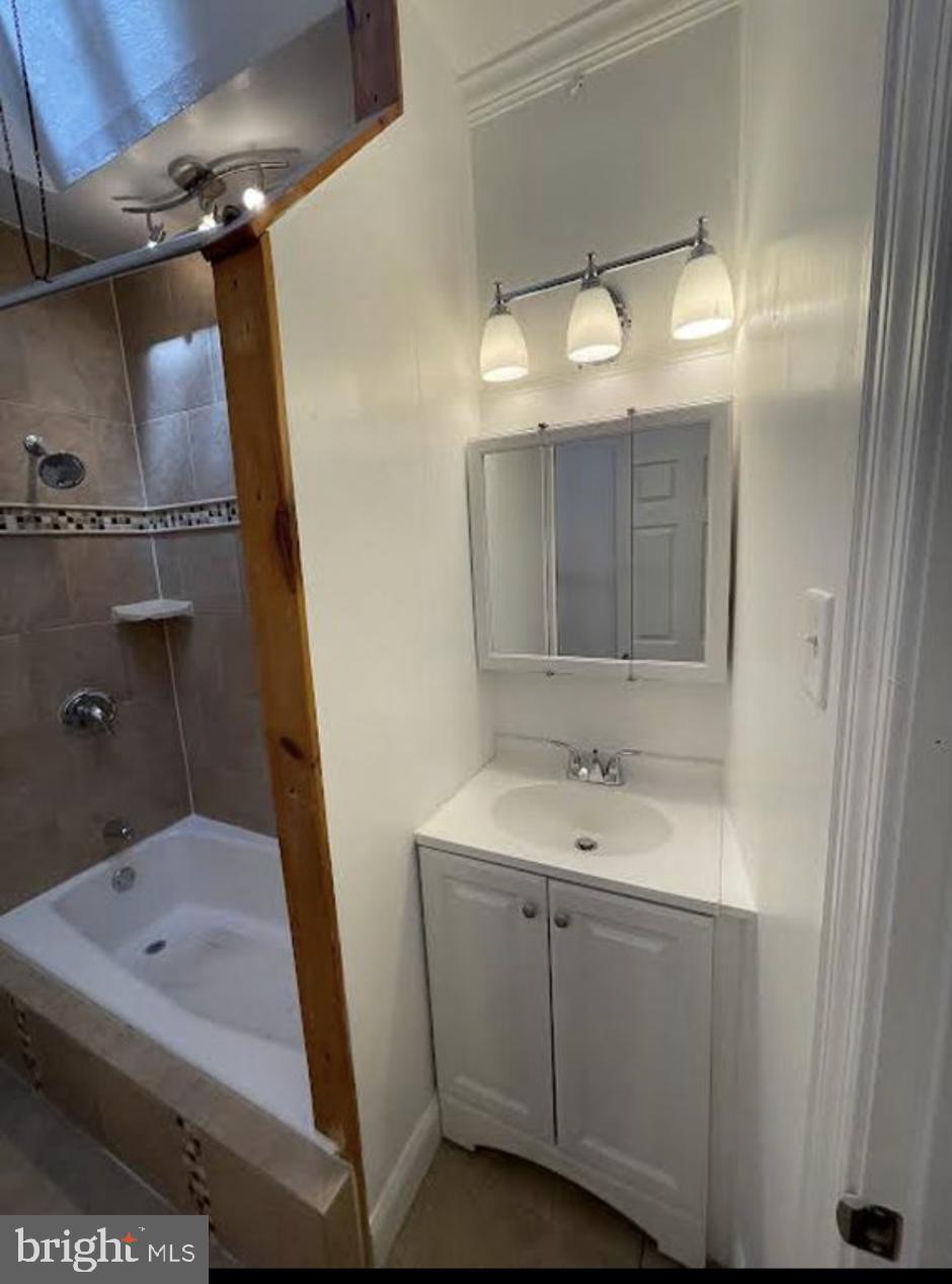 5616 Christian Street Philadelphia, PA 19143 - Photo 12 of 12 a bathroom with a sink and mirror