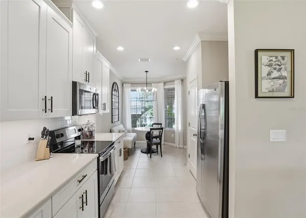 a kitchen with stainless steel appliances a refrigerator sink and white cabinets