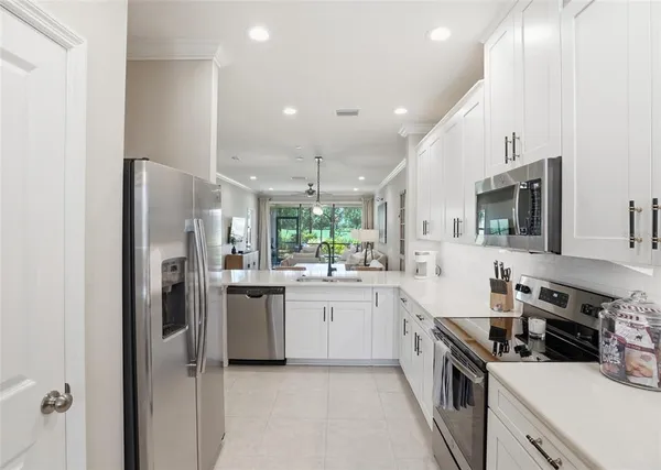 a kitchen with stainless steel appliances kitchen island a sink stove and refrigerator