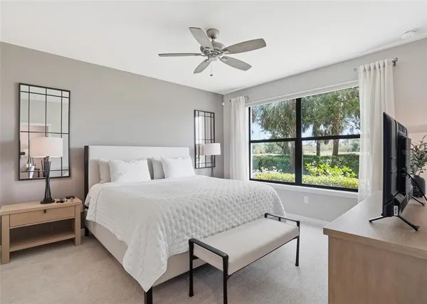 a bedroom with a bed window and a flat screen tv