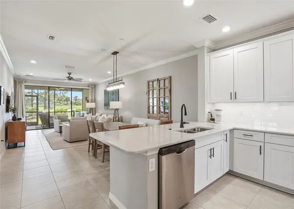 a large white kitchen with a sink and cabinets