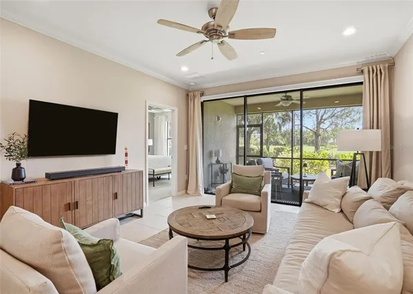 a living room with furniture a flat screen tv and a large window