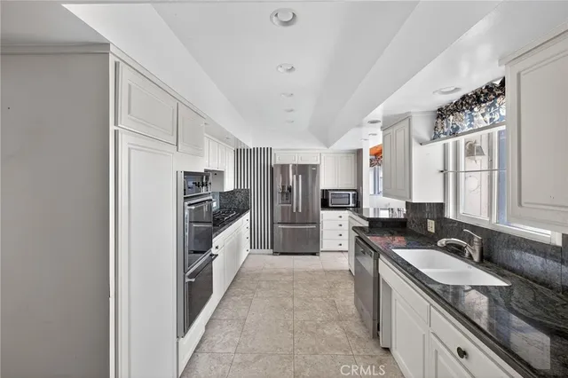 a view of a kitchen with stainless steel appliances granite countertop a refrigerator and a sink