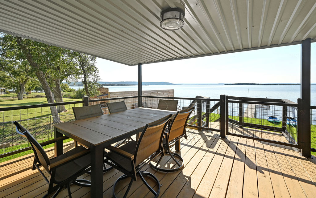 611 Lakeshore Loop Tow, TX 78672 - Photo 24 of 40 Wooden deck with a water view and outdoor dining area