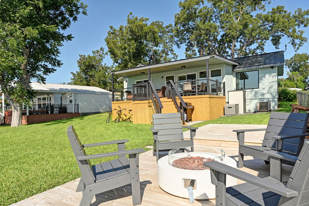 611 Lakeshore Loop Tow, TX 78672 - Photo 31 of 40 Rear view of property featuring a wooden deck, a yard, and an outdoor fire pit