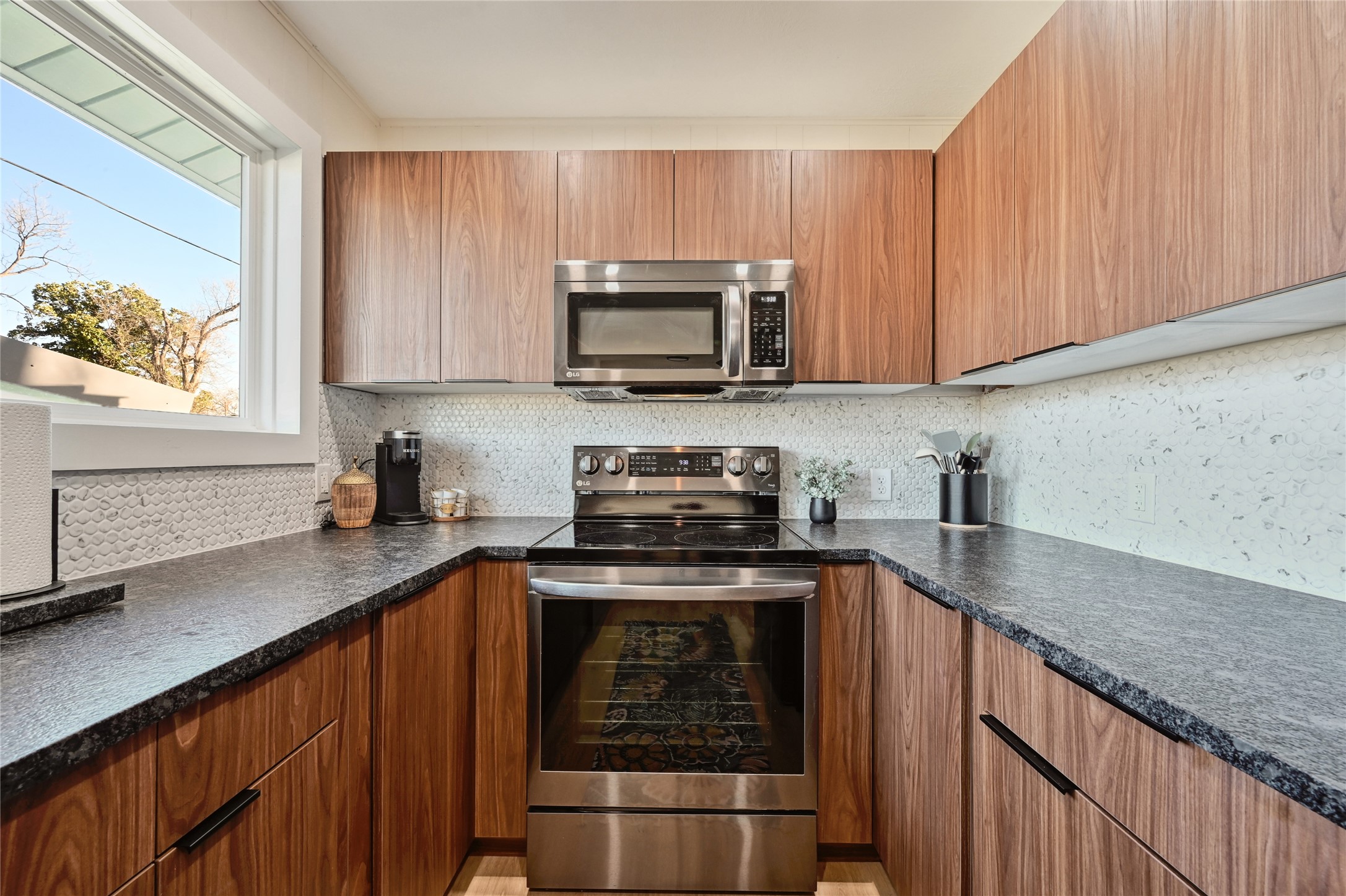 611 Lakeshore Loop Tow, TX 78672 - Photo 7 of 40 Kitchen featuring stainless steel appliances, wood finish cabinets, decorative backsplash, and modern cabinets