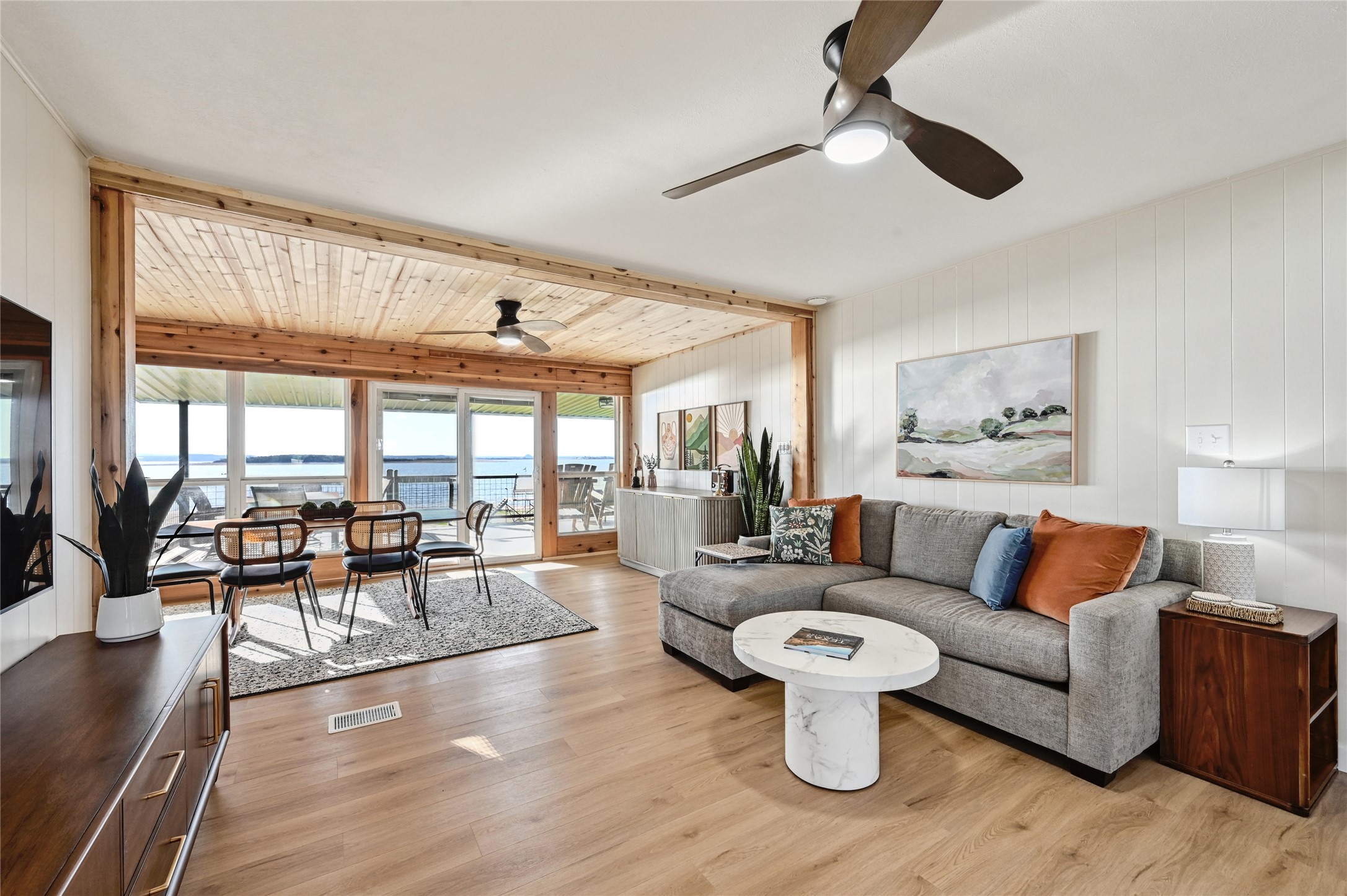 611 Lakeshore Loop Tow, TX 78672 - Photo 9 of 40 Living area featuring a ceiling fan, light wood finished floors, wood walls, and a water view