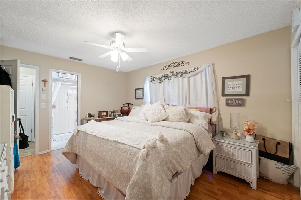12265 Shafton Road Spring Hill, FL 34608 - Photo 11 of 51 a spacious bedroom with a bed and a chandelier