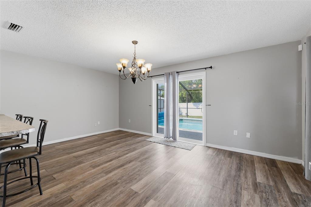 12265 Shafton Road Spring Hill, FL 34608 - Photo 11 of 58 a view of a livingroom with wooden floor and a chandelier