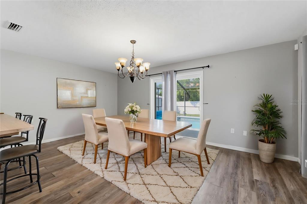12265 Shafton Road Spring Hill, FL 34608 - Photo 12 of 58 a view of a dining room with furniture window and wooden floor