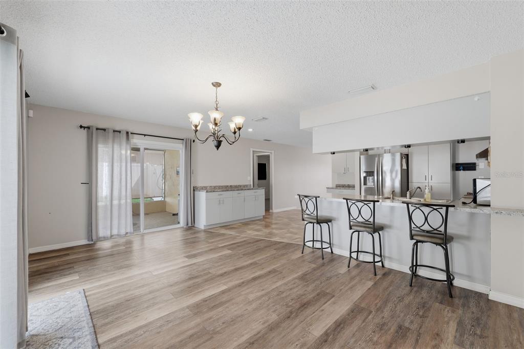 12265 Shafton Road Spring Hill, FL 34608 - Photo 13 of 58 a view of a dining room with furniture and wooden floor