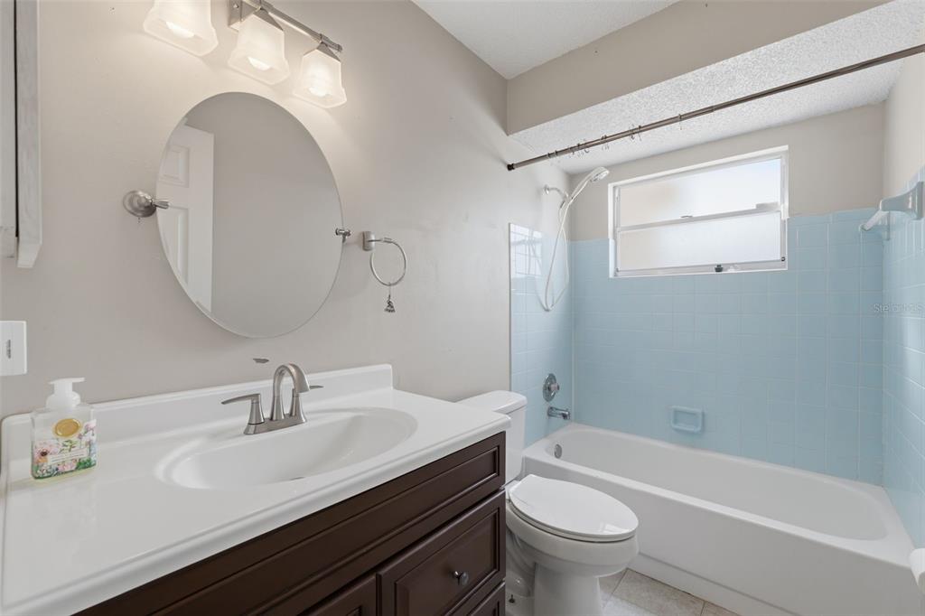 12265 Shafton Road Spring Hill, FL 34608 - Photo 16 of 58 a bathroom with a granite countertop sink a toilet and a mirror