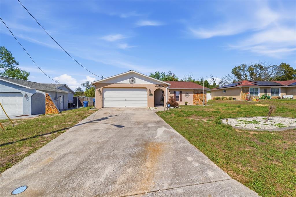 12265 Shafton Road Spring Hill, FL 34608 - Photo 2 of 58 a front view of a house with garden