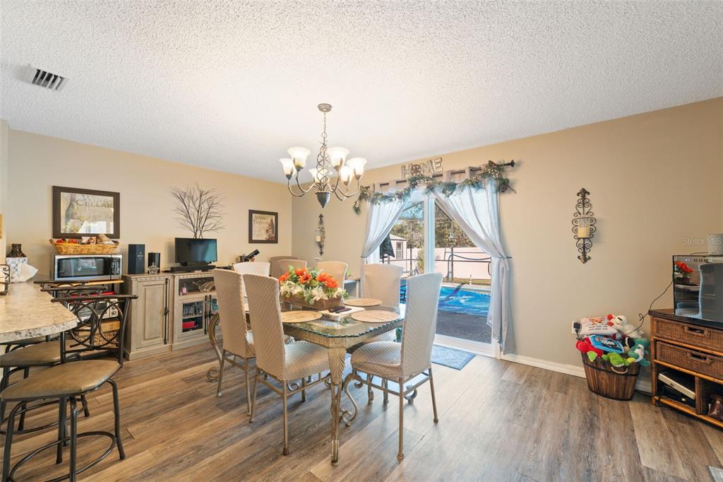 12265 Shafton Road Spring Hill, FL 34608 - Photo 48 of 51 a view of a dining room with furniture and wooden floor