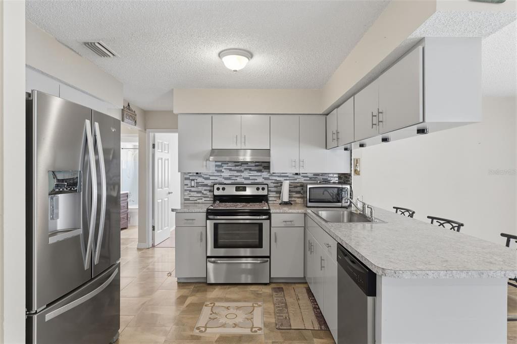 12265 Shafton Road Spring Hill, FL 34608 - Photo 51 of 58 a kitchen with a refrigerator sink and stainless steel appliances