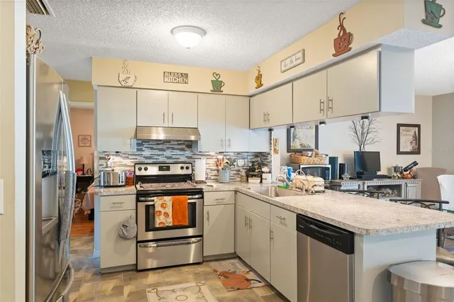 a kitchen with stainless steel appliances granite countertop a stove and cabinets