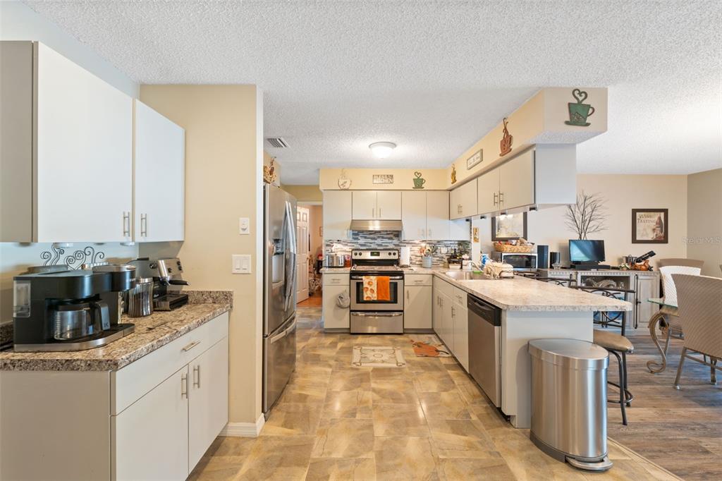 12265 Shafton Road Spring Hill, FL 34608 - Photo 9 of 51 a kitchen with stainless steel appliances granite countertop a stove and cabinets